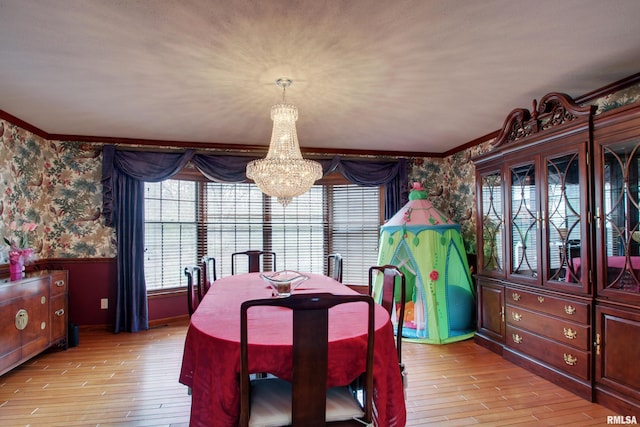 dining area with light hardwood / wood-style flooring, a chandelier, and ornamental molding