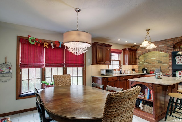 dining room featuring sink, light tile patterned floors, and a chandelier