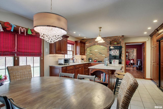 dining space featuring light tile patterned floors, sink, and a chandelier