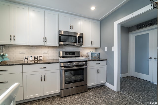 kitchen with backsplash, white cabinetry, dark stone counters, and appliances with stainless steel finishes