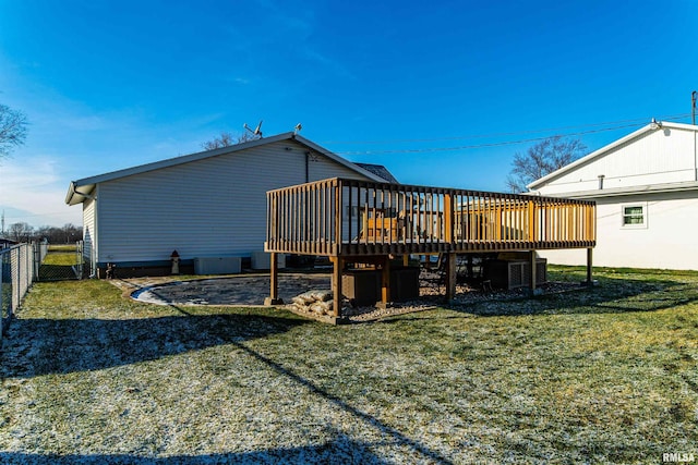 rear view of property with a wooden deck and a yard