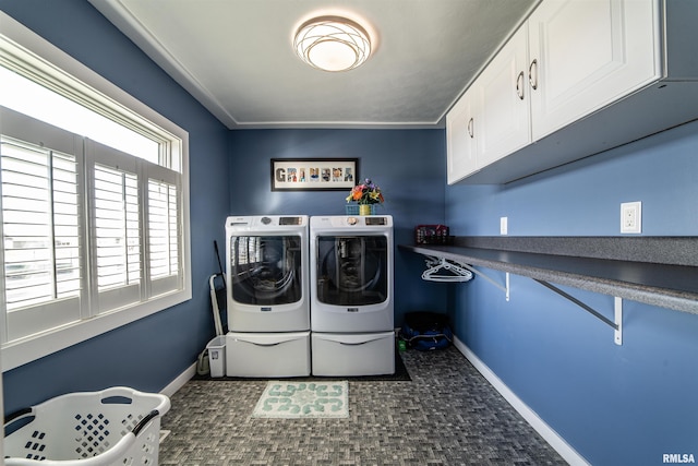 laundry area featuring crown molding, washer and clothes dryer, and cabinets