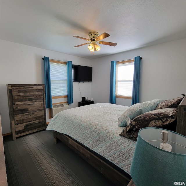 bedroom with an AC wall unit, ceiling fan, carpet, and a textured ceiling