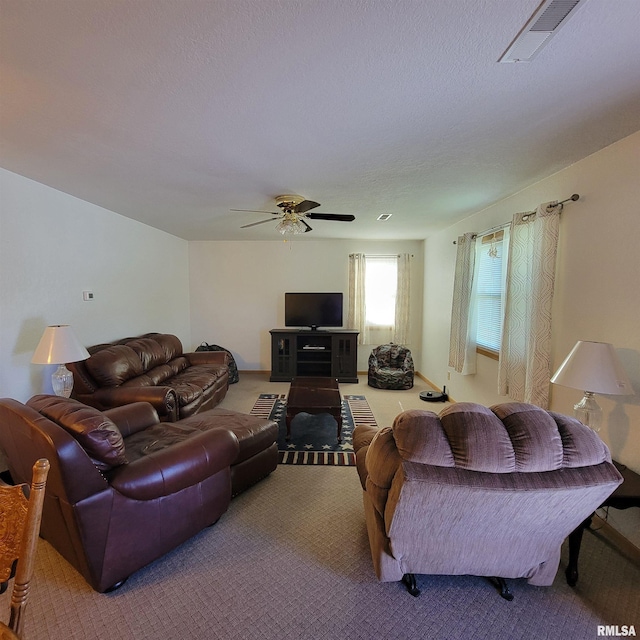 living room with ceiling fan, carpet, and a textured ceiling