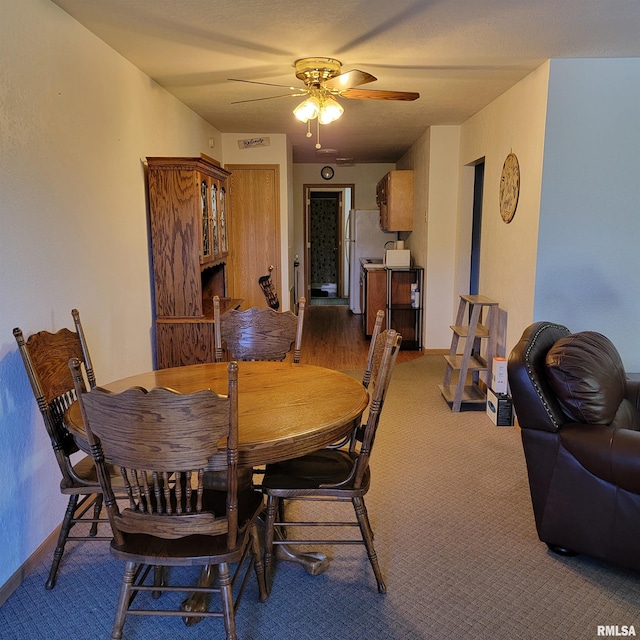 dining space with carpet flooring and ceiling fan