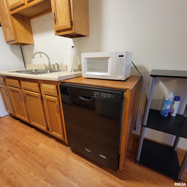 kitchen featuring sink, light hardwood / wood-style flooring, and black dishwasher