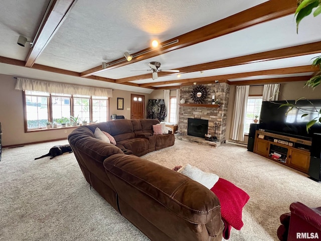 living room with beamed ceiling, carpet flooring, a healthy amount of sunlight, and a textured ceiling