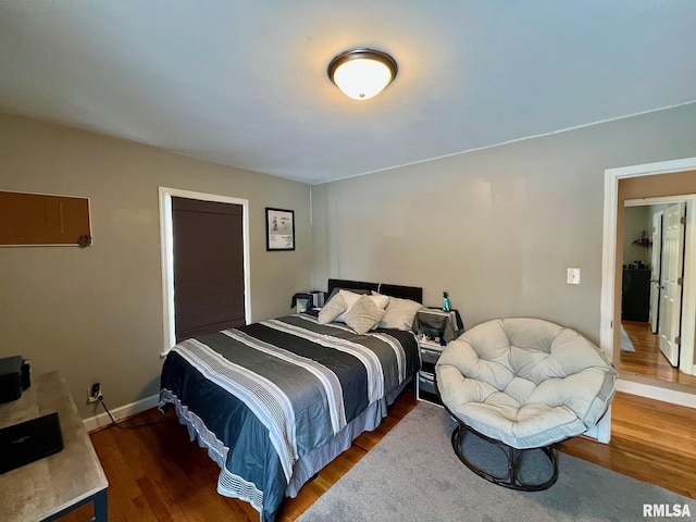 bedroom with dark hardwood / wood-style flooring