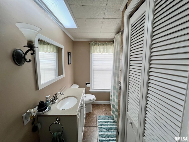 bathroom with tile patterned floors, vanity, ornamental molding, and toilet