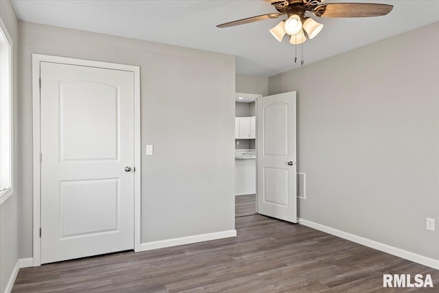 unfurnished bedroom with ceiling fan and dark hardwood / wood-style floors