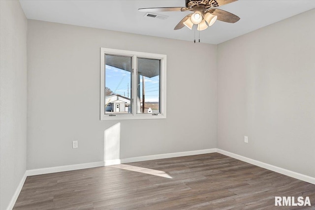 empty room with ceiling fan and dark wood-type flooring