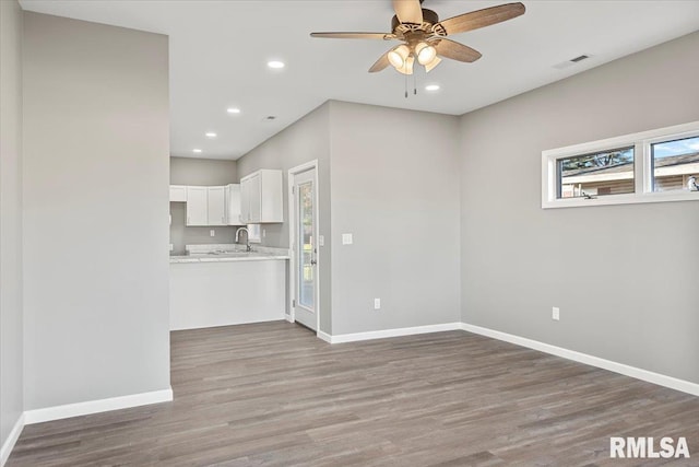 interior space featuring ceiling fan, sink, and wood-type flooring