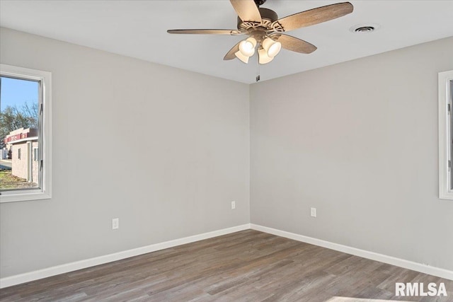 empty room with ceiling fan and dark wood-type flooring