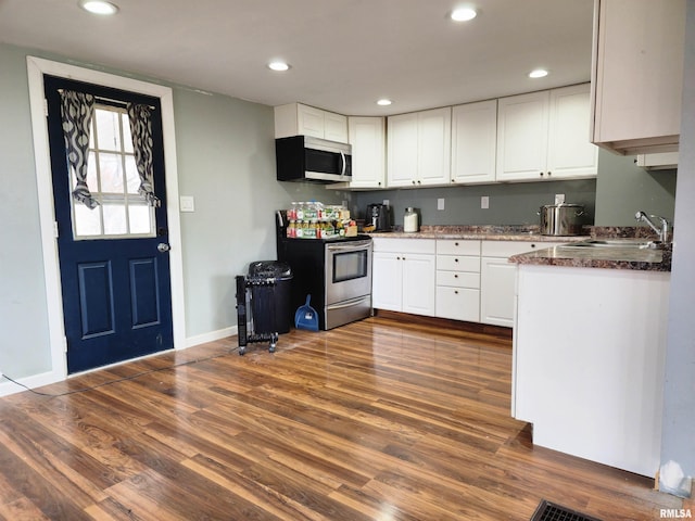 kitchen featuring dark hardwood / wood-style floors, white cabinetry, sink, and appliances with stainless steel finishes