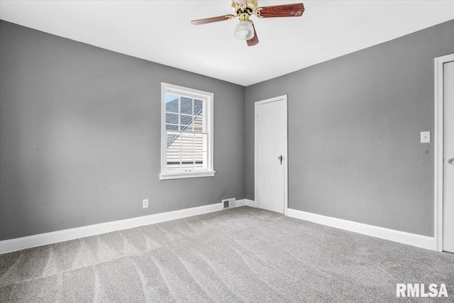 empty room featuring ceiling fan and carpet