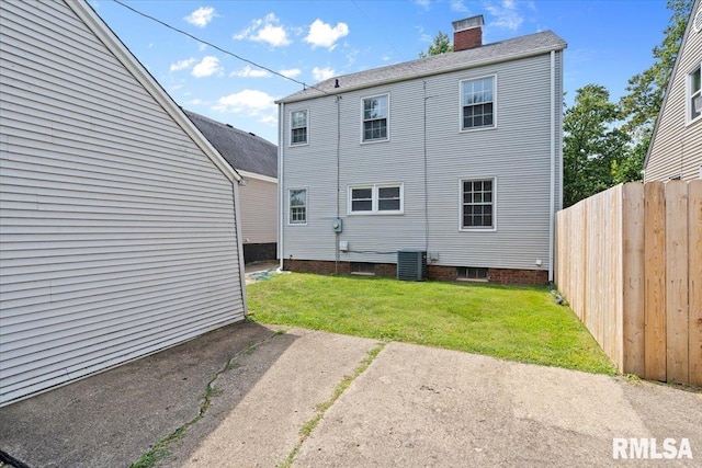 back of property with a lawn and central AC