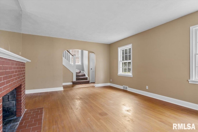 unfurnished living room featuring hardwood / wood-style flooring and a fireplace