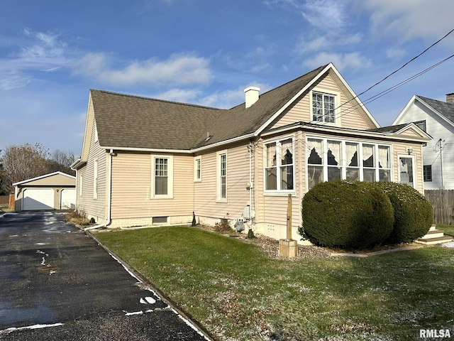 exterior space featuring a yard, an outbuilding, and a garage