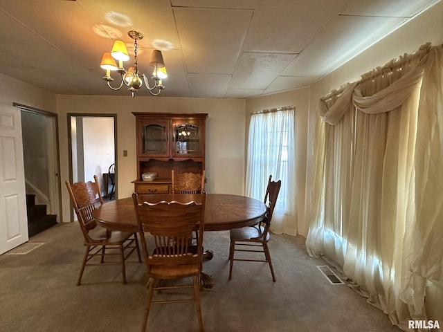 dining area with carpet flooring and a chandelier