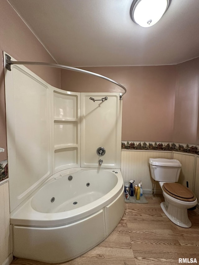 bathroom with shower / washtub combination, toilet, and hardwood / wood-style flooring