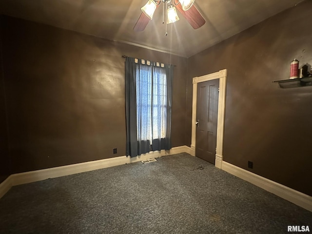 carpeted spare room with ceiling fan and vaulted ceiling