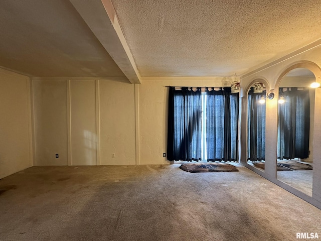 spare room featuring a textured ceiling and carpet floors