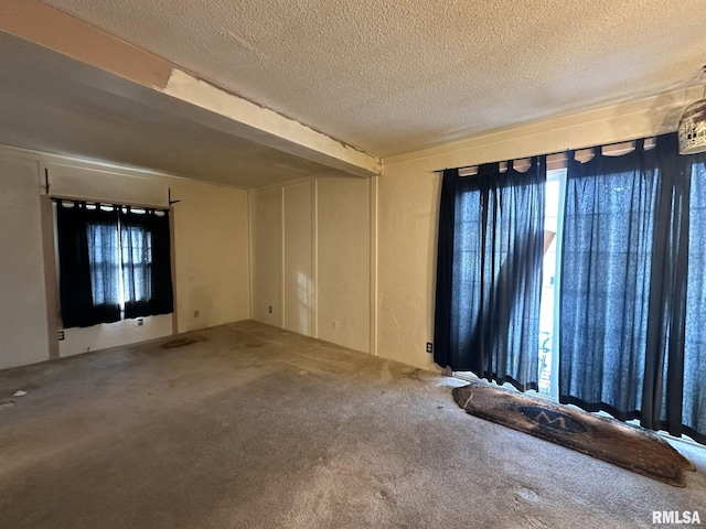 carpeted empty room with a textured ceiling