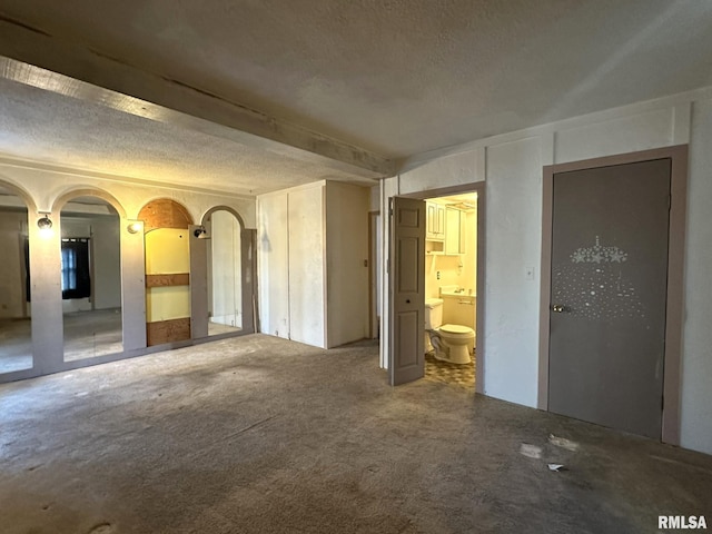 carpeted spare room featuring a textured ceiling