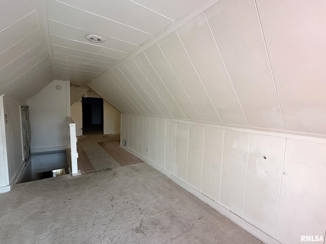 bonus room with carpet flooring and vaulted ceiling