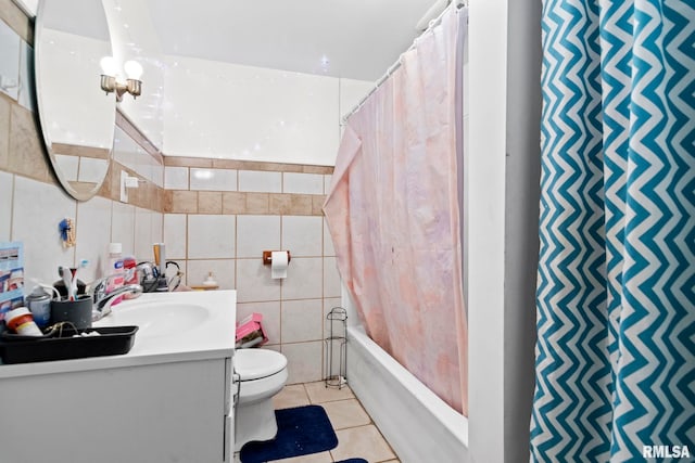 full bathroom featuring toilet, tile walls, vanity, shower / bath combo with shower curtain, and tile patterned flooring