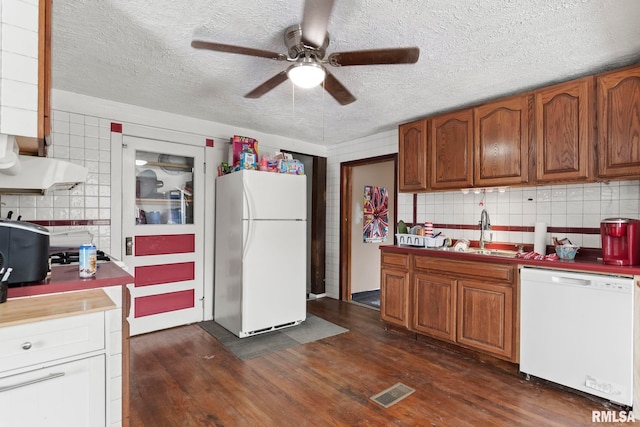 kitchen featuring sink, white appliances, ceiling fan, backsplash, and dark hardwood / wood-style flooring