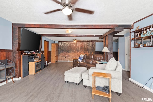 living room with beam ceiling, hardwood / wood-style flooring, and a textured ceiling