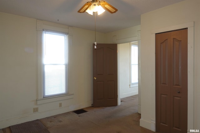 unfurnished room with ceiling fan and light carpet