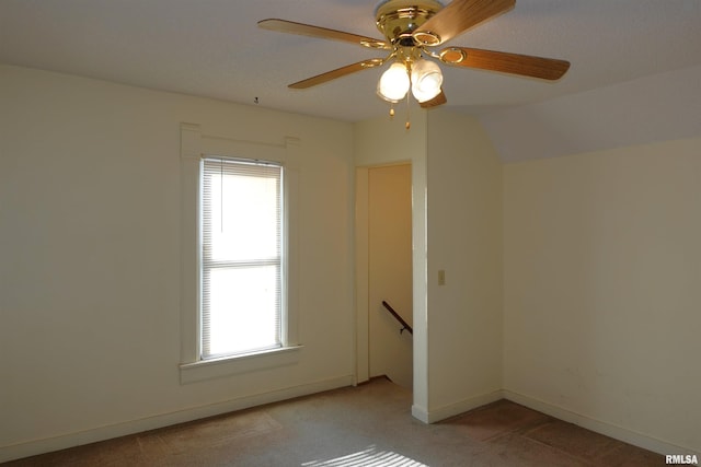 carpeted spare room featuring ceiling fan and lofted ceiling