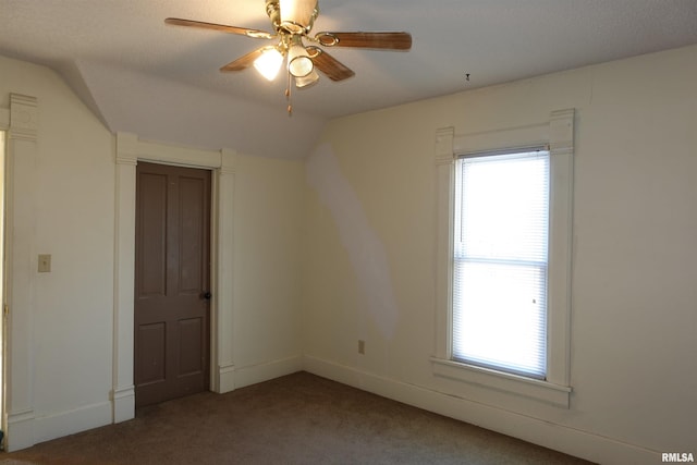 spare room featuring carpet, vaulted ceiling, and ceiling fan