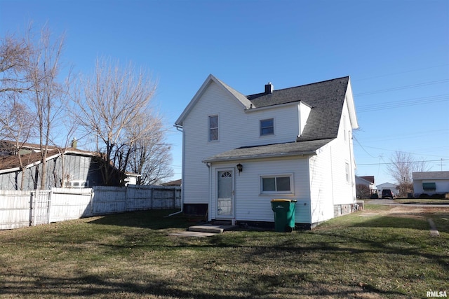 rear view of property featuring a lawn