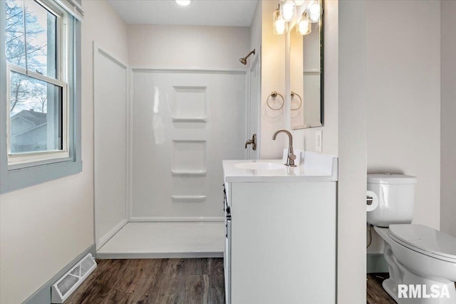 bathroom with vanity, a healthy amount of sunlight, and hardwood / wood-style flooring