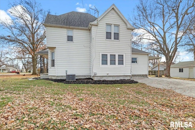 rear view of property with a yard and central AC unit