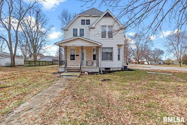 view of front of property with central AC unit, covered porch, and a front lawn