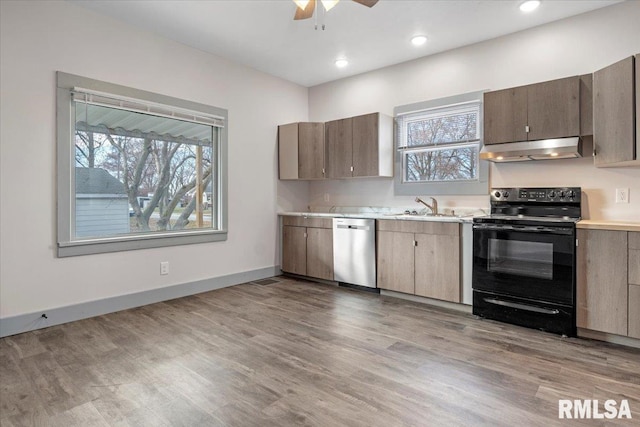 kitchen with dishwasher, sink, electric range, ceiling fan, and light hardwood / wood-style floors