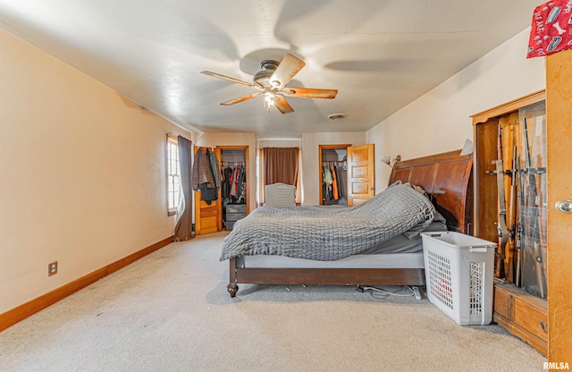 carpeted bedroom with ceiling fan, a walk in closet, and a closet