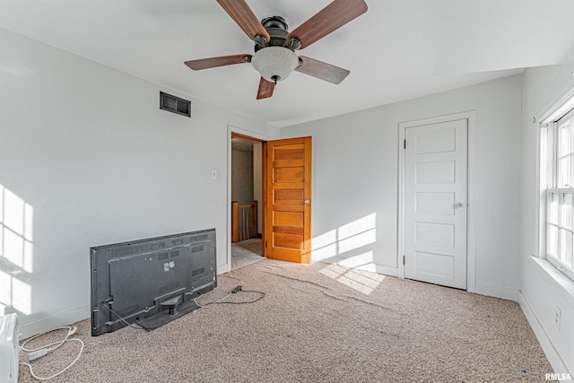 unfurnished bedroom with light carpet, multiple windows, and ceiling fan