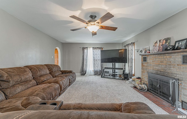 carpeted living room with ceiling fan and a brick fireplace