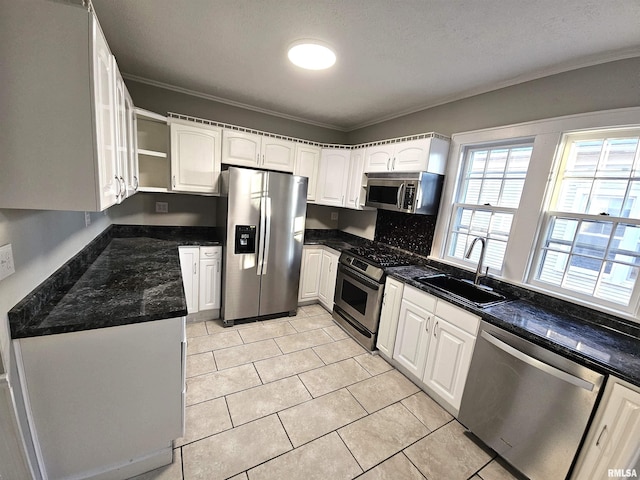 kitchen with sink, light tile patterned floors, ornamental molding, white cabinetry, and stainless steel appliances