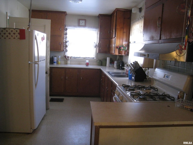 kitchen featuring kitchen peninsula, white appliances, and sink