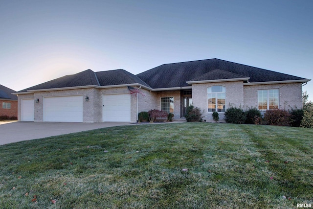 view of front of property with a garage and a yard