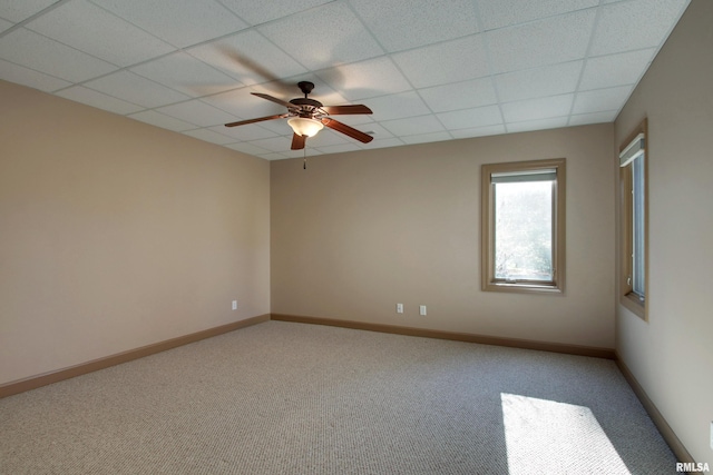 carpeted empty room with a drop ceiling and ceiling fan