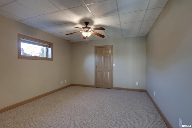 carpeted spare room with a paneled ceiling and ceiling fan