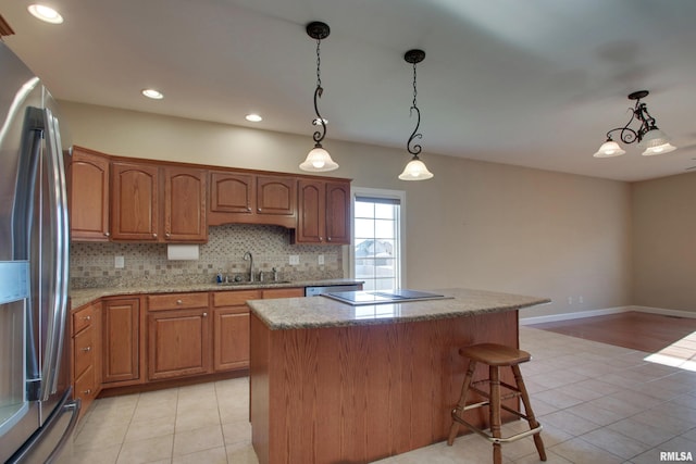 kitchen with stainless steel appliances, sink, a chandelier, a kitchen island, and hanging light fixtures