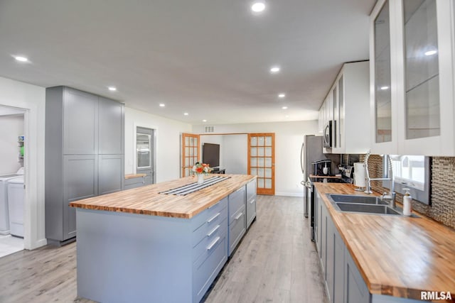 kitchen featuring appliances with stainless steel finishes, gray cabinets, sink, and butcher block counters